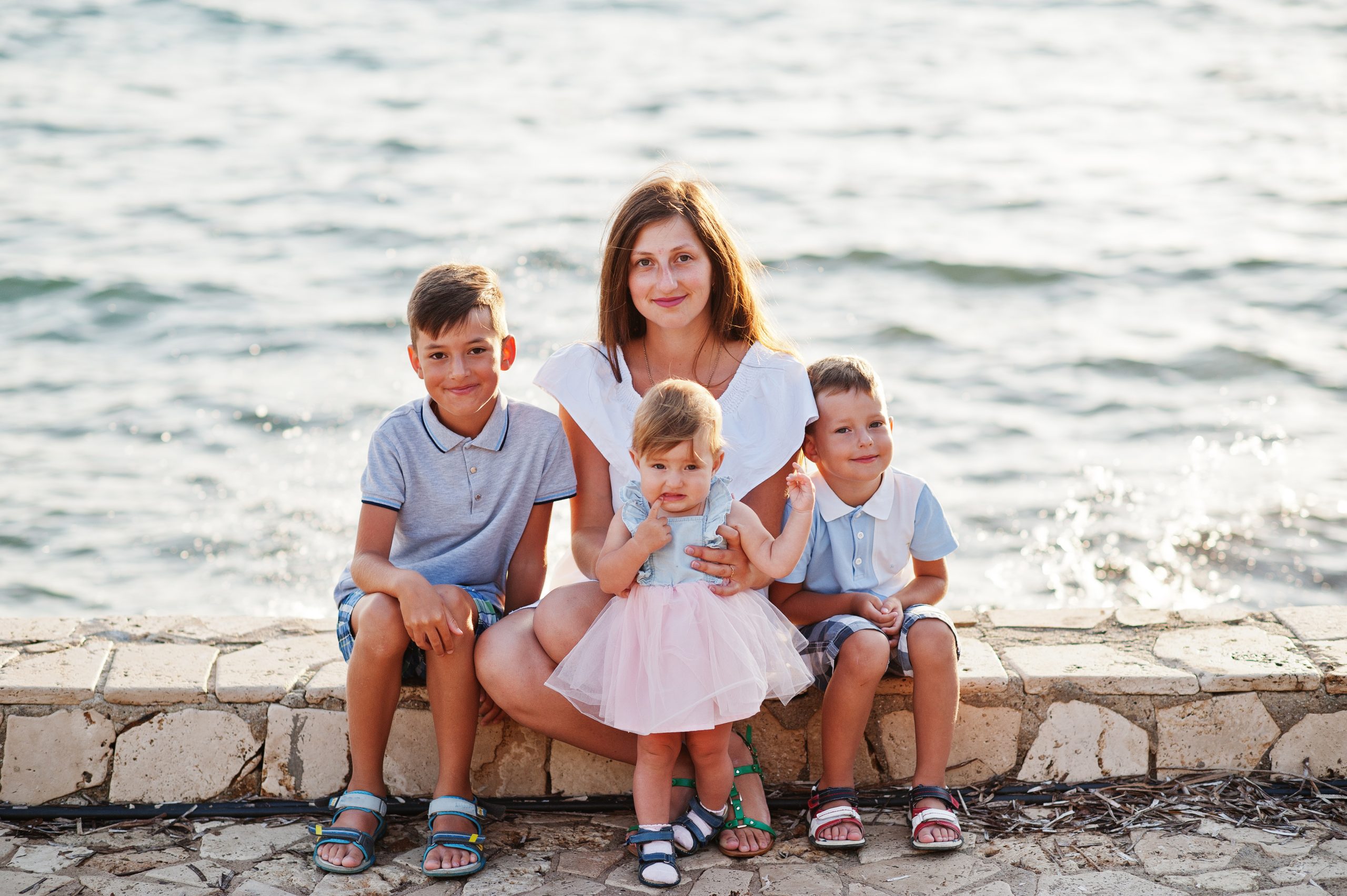 Mother with three kids on Turkey resort against Mediterranean sea.
