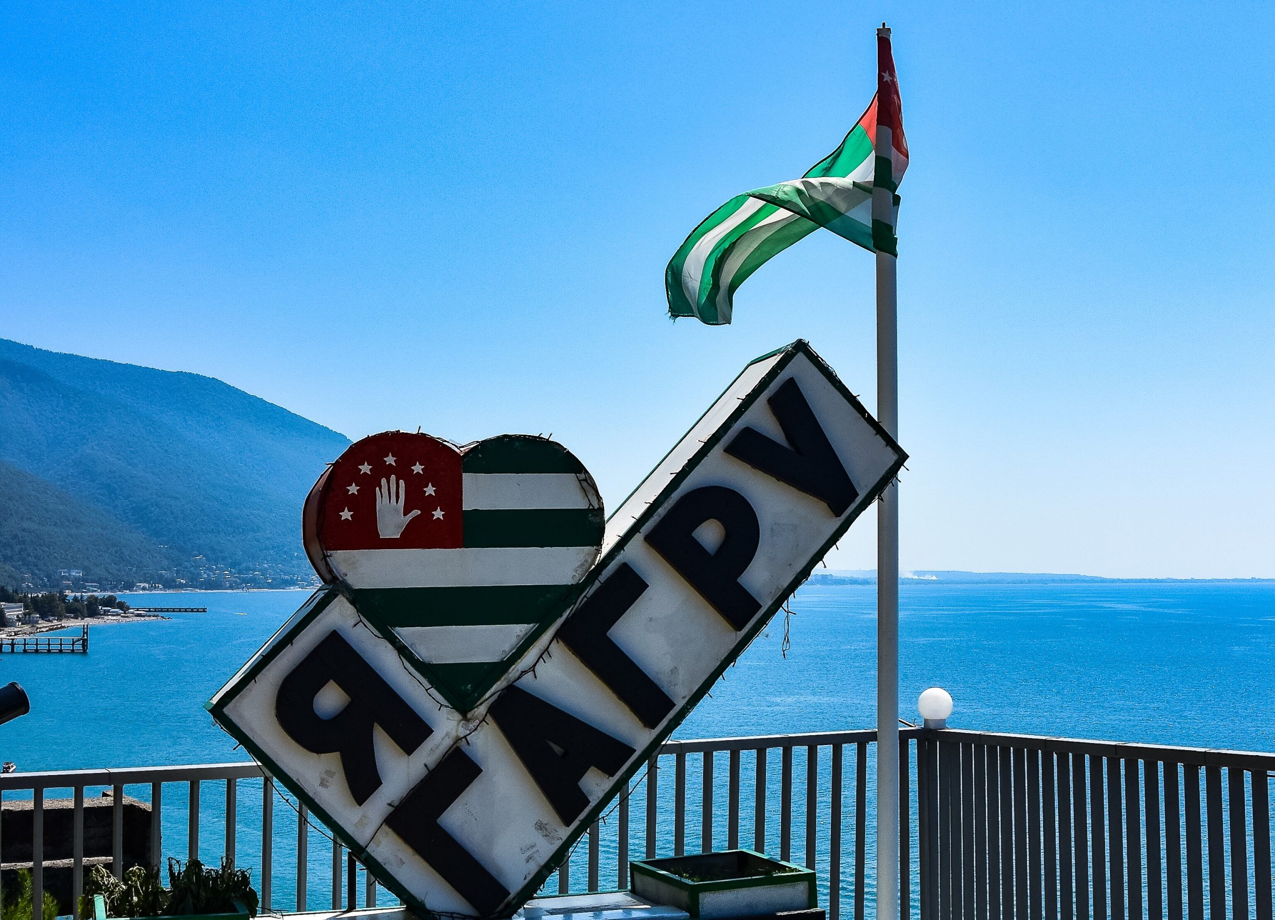 GAGRA, ABKHAZIA: 2019. View of the Black Sea and the flag of Abkhazia.