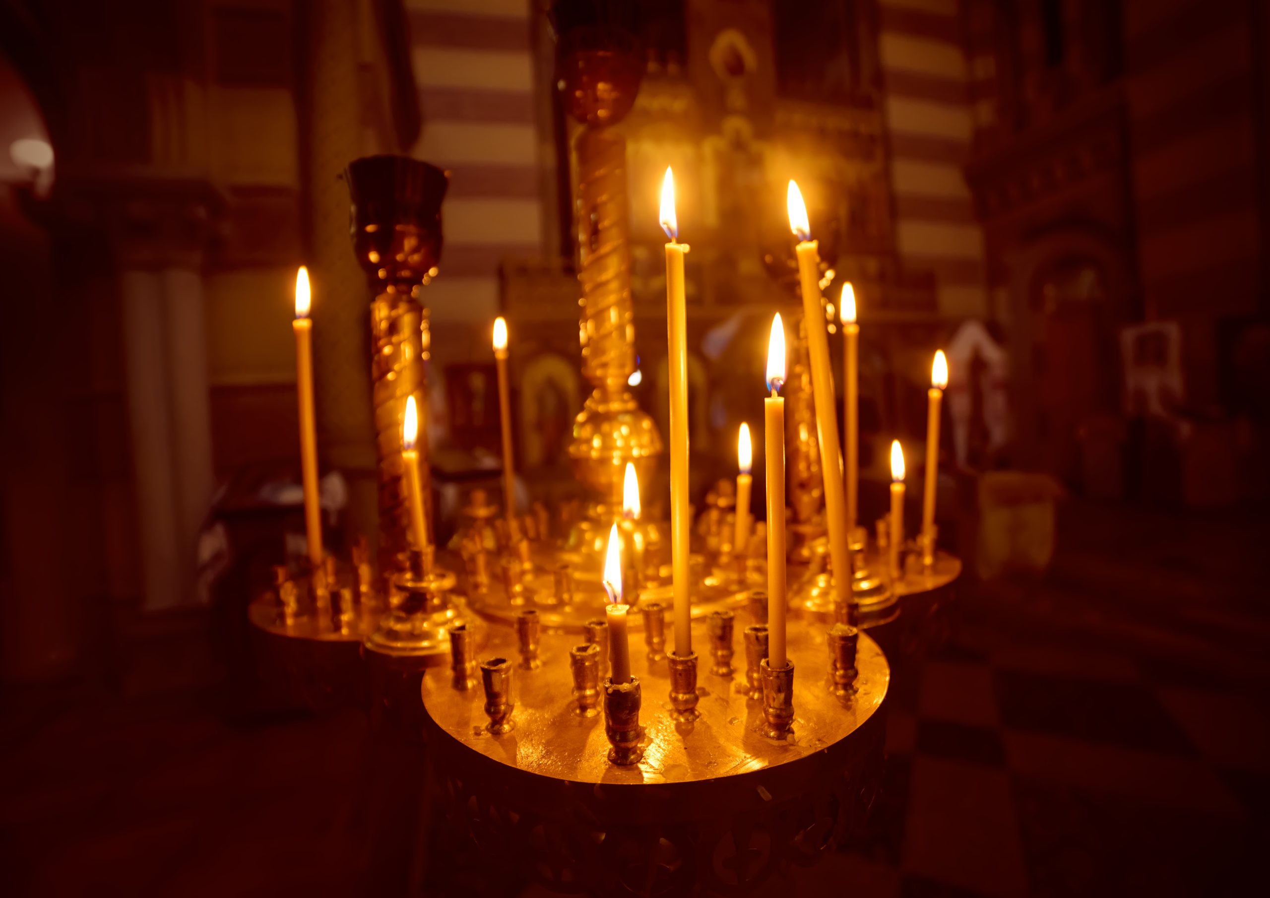 A lot of burning candles with shallow depth of field in the orthodox church, religion concept