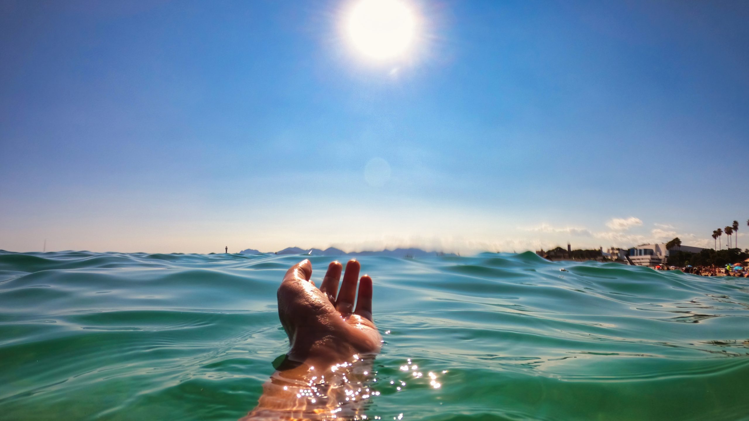 A man holding hand above the water of the Mediterranean sea